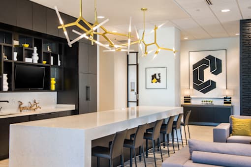 A modern kitchen with a white countertop and black cabinets at The Olivia Apartments, Indiana