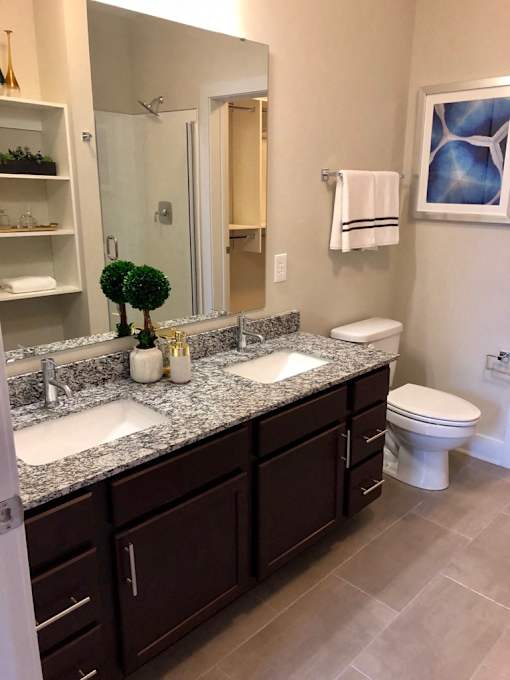 A bathroom with a double sink vanity and a toilet at The Olivia Apartments, Carmel, IN