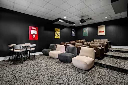 A room with black walls and a patterned carpet with several chairs and a table.
