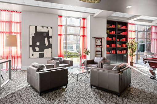 A living room with two grey couches and a large abstract painting on the wall.