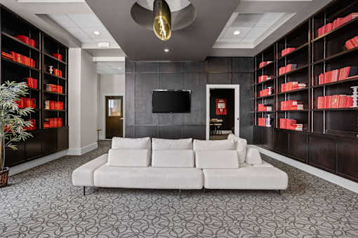 A living room with a white couch and a television on the wall.