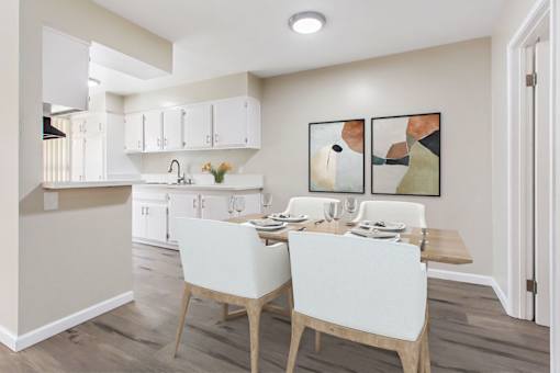 A kitchen with a dining table and chairs.