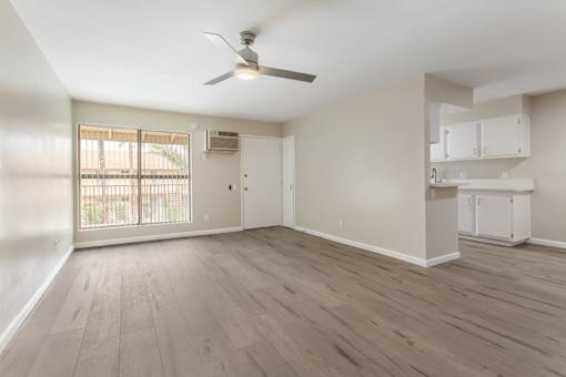 A room with a ceiling fan and wooden flooring.