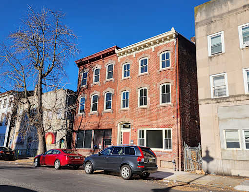 A red brick building with a green lawn in front.