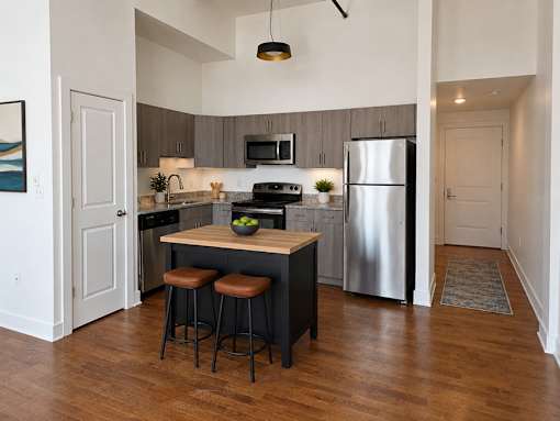 A kitchen with a wooden island and stools.
