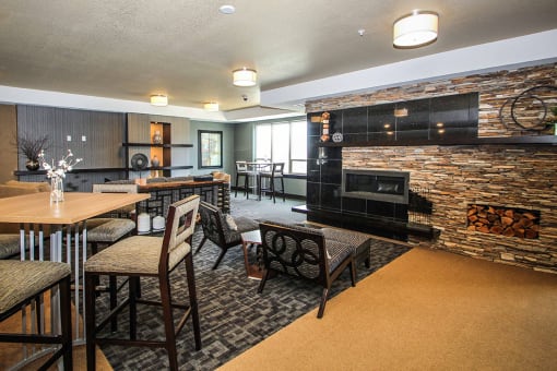 a community room with tables and chairs and a fireplace at The Flats at Cedar Grove, Minnesota, 55122