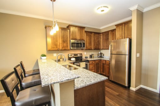 a kitchen with a large island and stainless steel appliances at The Flats at Cedar Grove, Eagan, MN, 55122