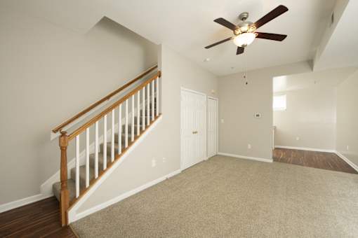 an empty living room with a ceiling fan and a staircase at Queen Anne Belvedere, Baltimore, Maryland