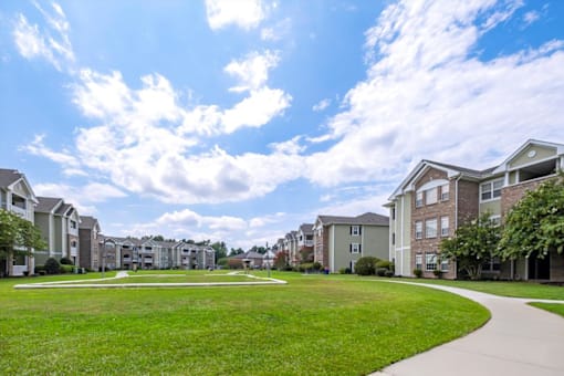 A row of houses with a green lawn in front.