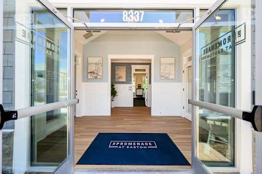 The entrance to a building with a blue mat that says at The Promenade at Easton Apartments, Easton, MD