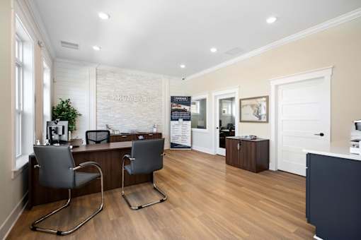 Two chairs are placed in front of a desk with a computer at The Promenade at Easton Apartments, Easton