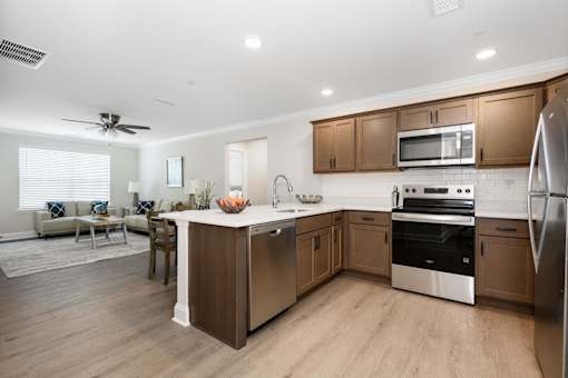 A modern kitchen with wooden cabinets and stainless steel appliances at The Promenade at Easton Apartments, Maryland