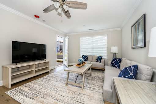 A living room with a television, couch, and coffee table at The Promenade at Easton Apartments, Easton, MD