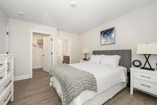 A bedroom with a large bed and a painting on the wall at The Promenade at Easton Apartments, Easton, 21601