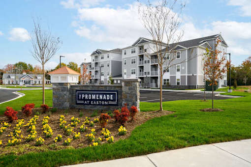 Promenade at Easton is a residential complex with a well-maintained lawn and flower beds at The Promenade at Easton Apartments, Easton