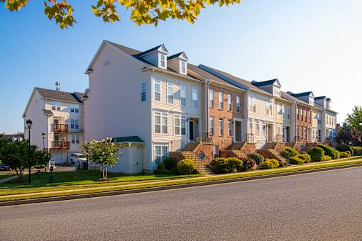 a row of houses on the side of a street at Townes at Village Center Apartments, Maryland