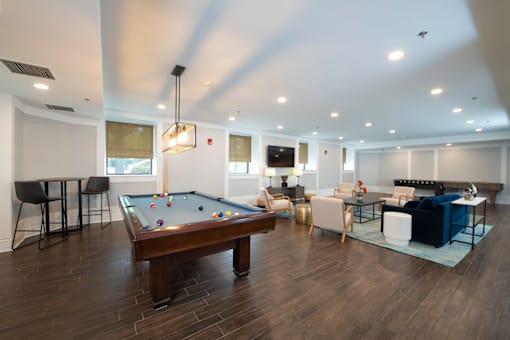 A billiard table is in the middle of a room with a pool table.