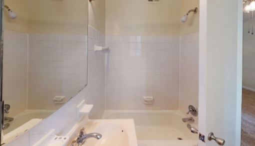 A white bathroom with a tub and shower.
