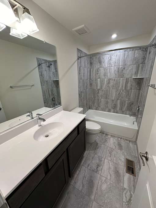 A bathroom with a sink, toilet, and bathtub.