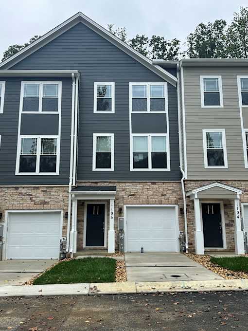 A row of three houses with garages in front.