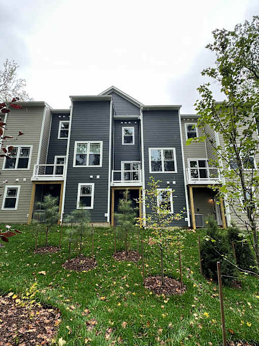 A grey house with a green lawn in front.