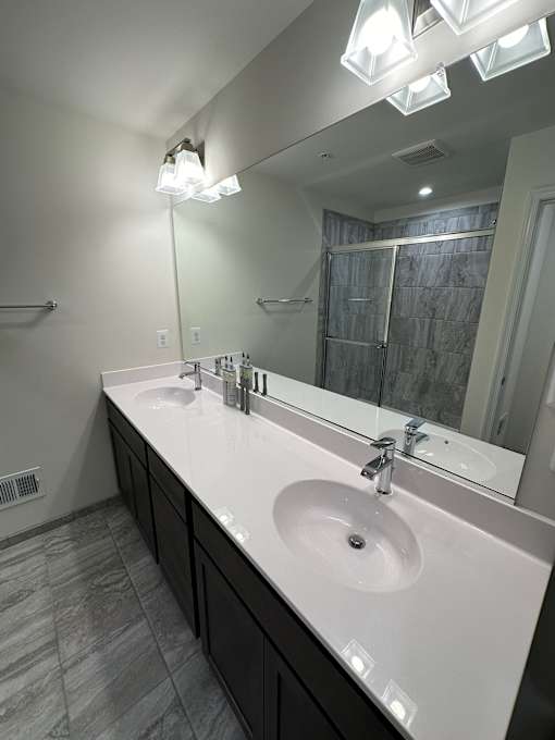 A bathroom with two sinks and a large mirror.