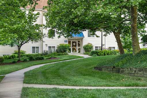 A building with a blue sign on it is surrounded by greenery. at West Woods, Annapolis, Maryland