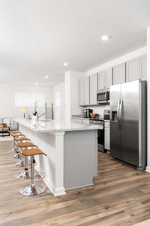 A modern kitchen with a bar and stools.at Forge Overlook, Maryland, 21227