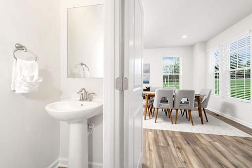 A white bathroom with a white sink and a white chair. at Forge Overlook, Halethorpe