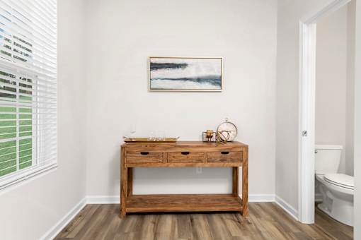 A bathroom with a wooden vanity and a painting on the wall. at Forge Overlook, Halethorpe