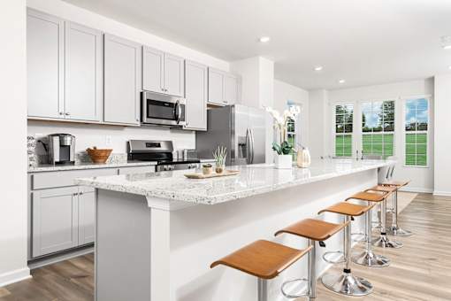 A kitchen with white cabinets and a marble countertop. at Forge Overlook, Halethorpe