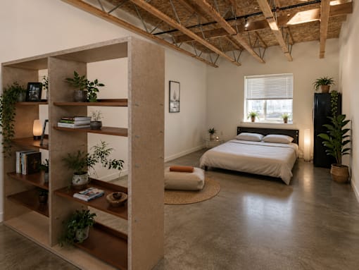 A bedroom with a bed, a shelf, and a rug.