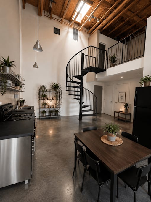 A modern kitchen with a stainless steel refrigerator and a wooden dining table.