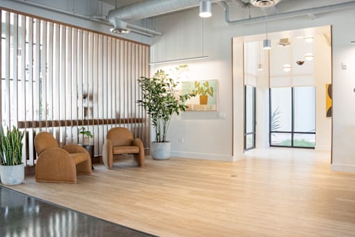 A room with a wooden floor and a large window with vertical blinds.