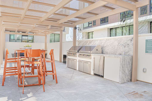 A kitchen area with a table and chairs.