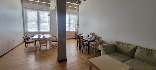 A living room with a couch, chairs, and a dining table.