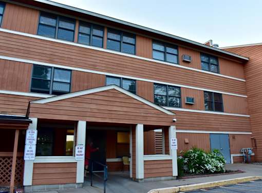 A building with brown siding and a covered entrance.