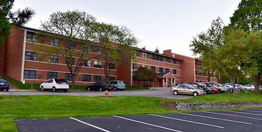 A parking lot in front of a brick building.