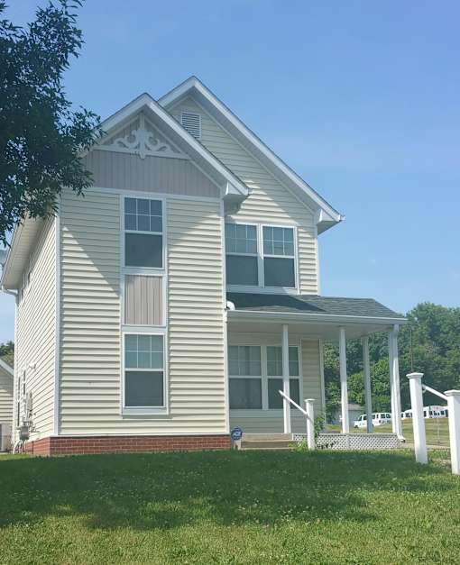 A house with a grey siding and a white trim.