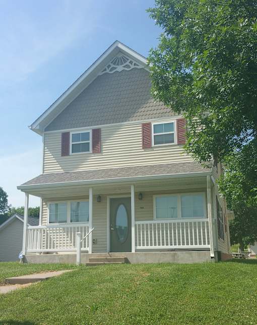 A house with a grey roof and a green door.