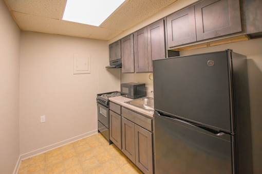 A kitchen with a black refrigerator and stainless steel appliances.