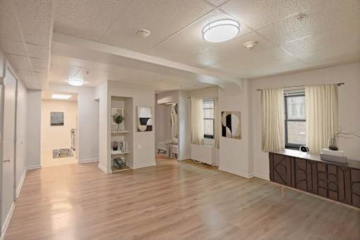 A spacious room with wooden floors and white walls.