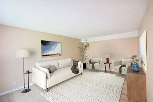 A living room with a white couch and a painting on the wall.