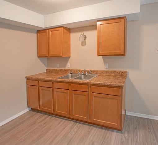 A kitchen with brown cabinets and a granite countertop.