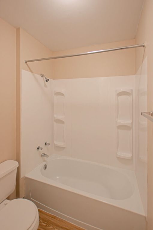 A white bathroom with a toilet, tub and shower.