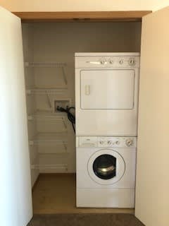 A white oven and washing machine in a small room.