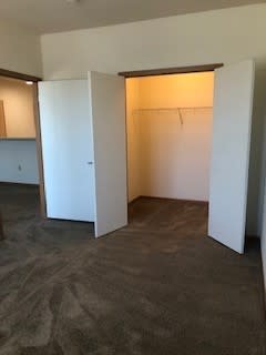 A room with a carpeted floor and a white door.