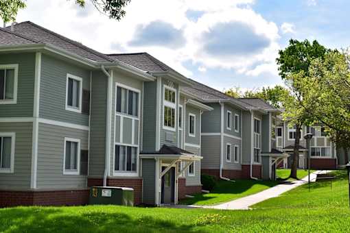 A row of houses with green lawns in front.