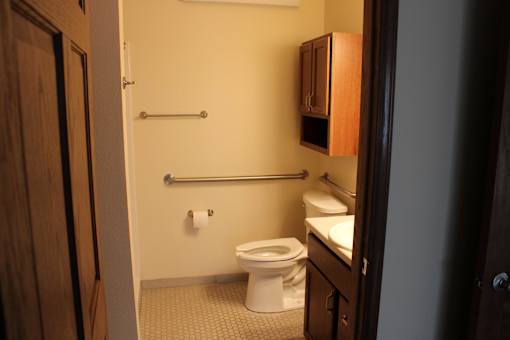 A small bathroom with a toilet, sink and a towel rack.