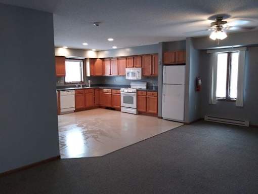 A kitchen with brown cabinets and white appliances.